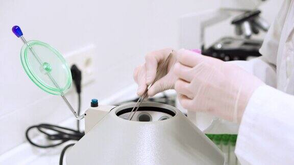 现代化的实验室设备离心验血和医生手戴手套取出试管