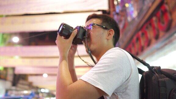 泰国曼谷Yaowarat夜市一名男性摄影师正在拍摄夜市的照片