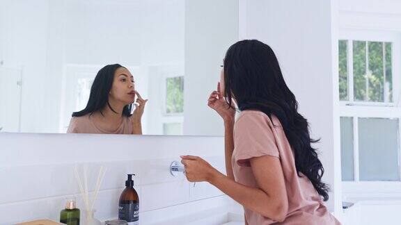 家里的镜子浴室和女人用唇彩补水涂口红和早上例行公事反射、美容和化妆人员做皮肤护理、口腔护理或涂抹化妆品产品