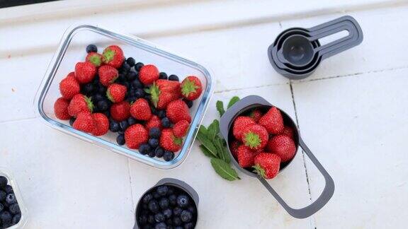草莓、蓝莓和覆盆子装在塑料容器里