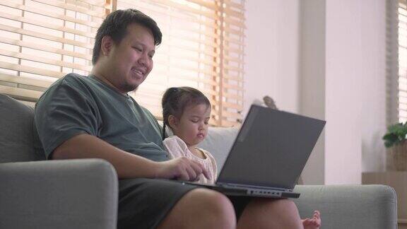父亲和女儿喜欢在家用笔记本电脑看电影