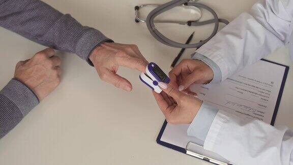 护士用手指脉搏血氧计测量病人血氧饱和度