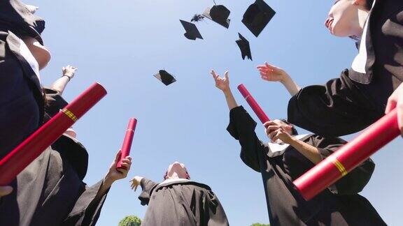 一群快乐的毕业生扔帽子