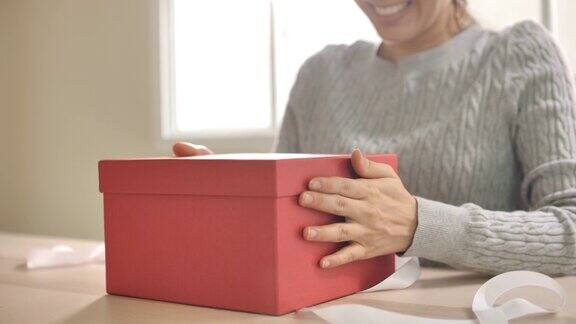 快乐的亚洲女人打开礼品盒