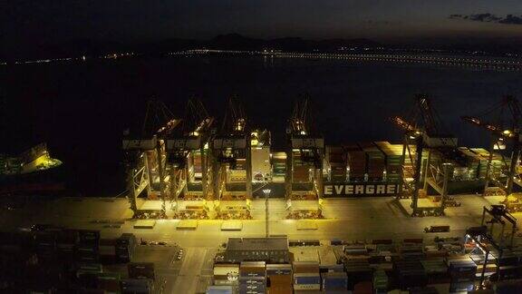 晚上一个海港仍在一艘货船上装载集装箱