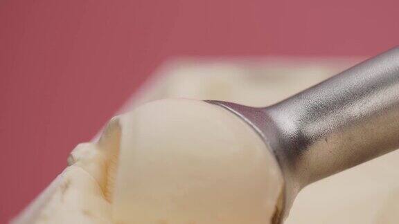 用勺子从容器中舀出香草冰淇淋不锈钢前视图食物概念