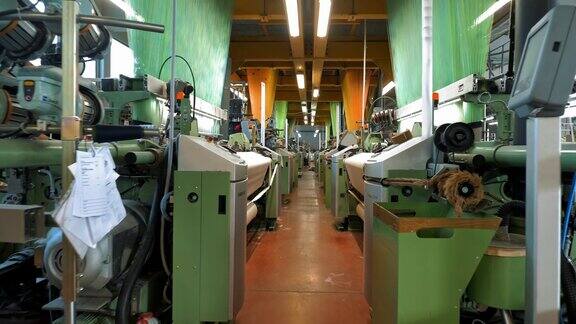 编织织机纺织工厂许多自动织布机在车间里工作编织