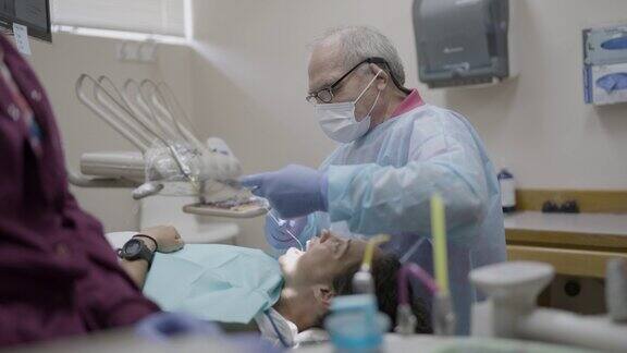 经验丰富的牙科医生为成年女性病人提供口腔护理