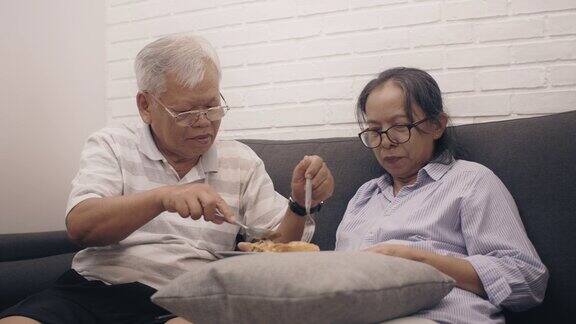 亚洲老夫妇喂面包在卧室的家庭背景周末度假老年人幸福生活