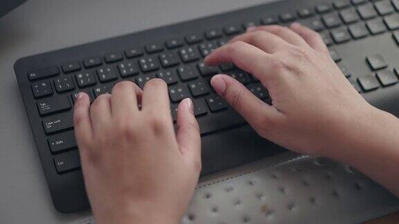人类的手在电脑键盘上打字的特写