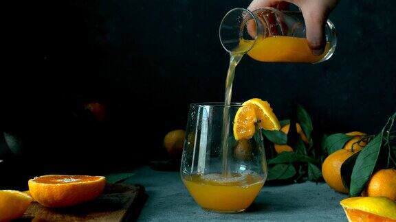 用手轻轻将陈年瓶中的橘子橙汁倒入玻璃杯