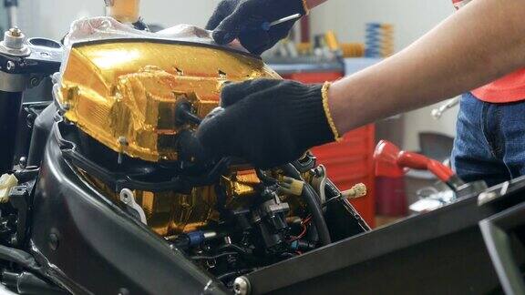 工人在调整摩托车内部的空气过滤器