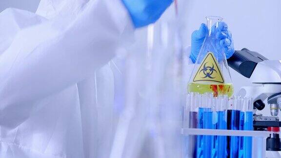 科学家穿着个人防护装备在实验室的试管中做一些研究检查一种液体