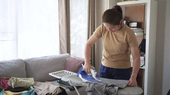 女仆在客厅用熨衣板熨衬衫