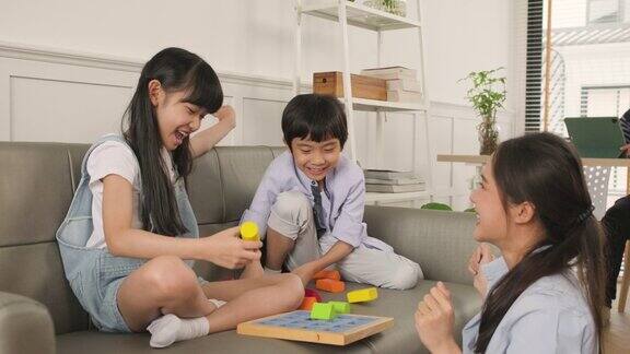 幸福的亚洲家庭妈妈和孩子们一起在沙发上玩五颜六色的玩具