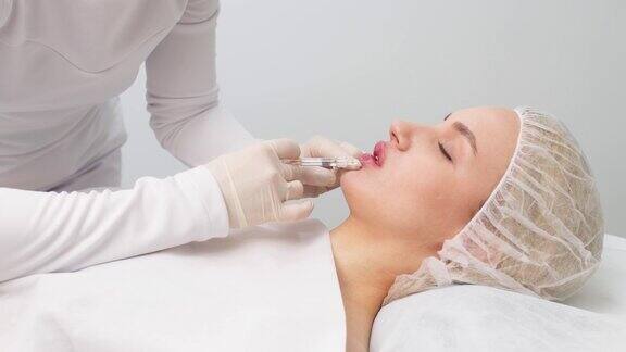 丰唇注射程序特写美容师慢慢地、小心地把填充物注射到顾客的嘴唇里广告理念:面部护理青春美丽