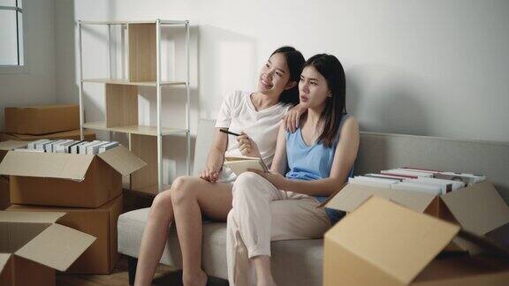 亚洲年轻女性坐在沙发上讨论新家的室内设计