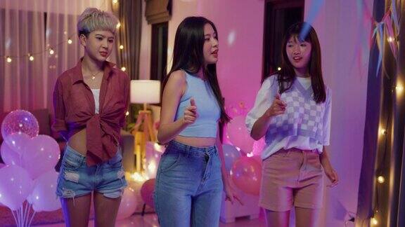 抖音的年轻亚洲女性朋友们用智能手机制作了她的舞蹈视频晚上在多彩的家庭派对上玩得很开心