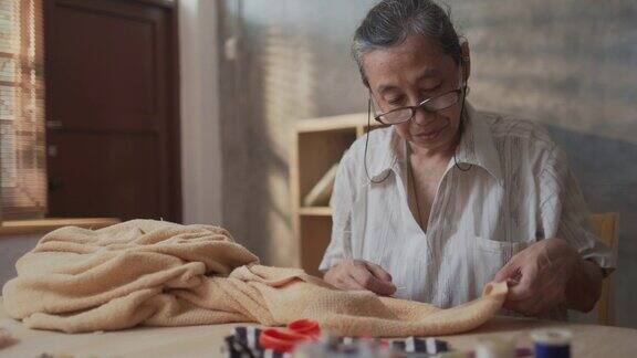 女裁缝高级妇女缝纫织物修补毛毯