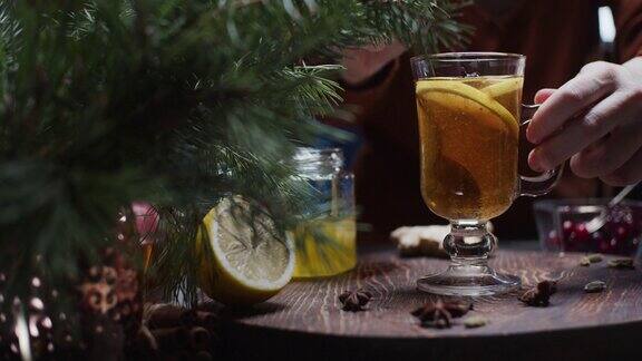 人们正在用手准备柠檬和蜂蜜的圣诞风味茶