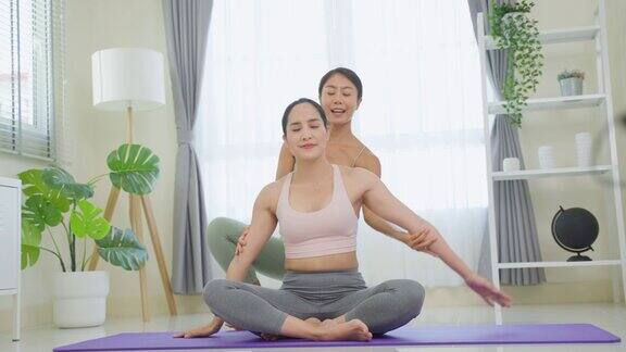 亚洲活跃的运动女性学习瑜伽普拉提课教练教练迷人的年轻女孩穿着运动服在客厅用垫子锻炼在家里跟随健身教练锻炼健康