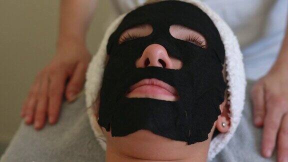 一个戴着黑色面罩的年轻女子躺在水疗中心