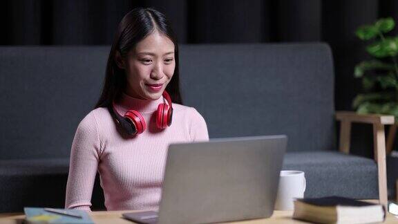 年轻的亚洲女性在家里使用笔记本电脑她正在工作和观看网络研讨会