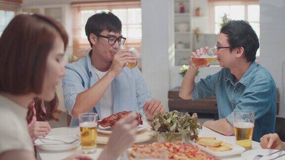 快乐的亚洲朋友享受啤酒在家里朋友用餐和聚会