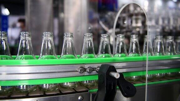 透明的玻璃瓶在自动输送系统上传输工业自动化包装