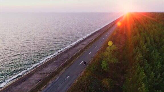 鸟瞰图摩托车手在海上道路上行驶