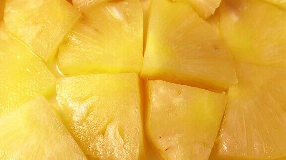明亮甜美的罐装黄色菠萝片圆旋转近俯视图