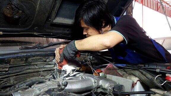 亚洲发动机技师正在修理发动机