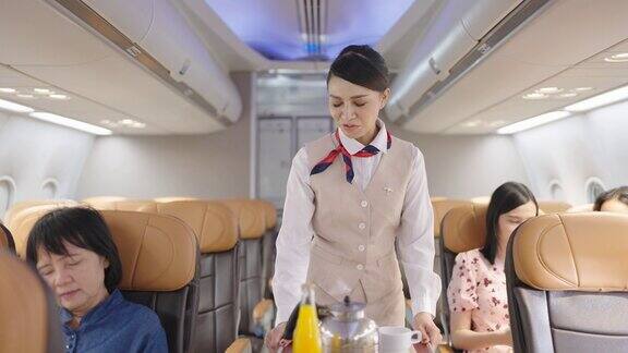 在飞机上为乘客提供食物和饮料的亚洲女性空姐航空公司服务