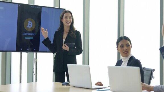 业务介绍东南亚在会议室的显示器上女商人向同事介绍加密货币投资