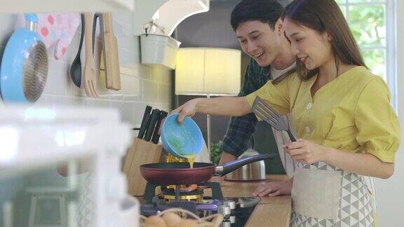 年轻夫妇在家里帮忙做饭营造浪漫的气氛在厨房里情侣们通过帮助对方做早餐来表达爱意