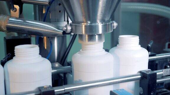 工业机器将药品放入塑料瓶中