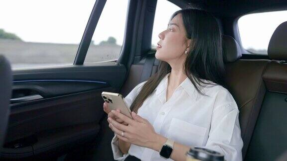 亚洲女商人在车里使用智能手机
