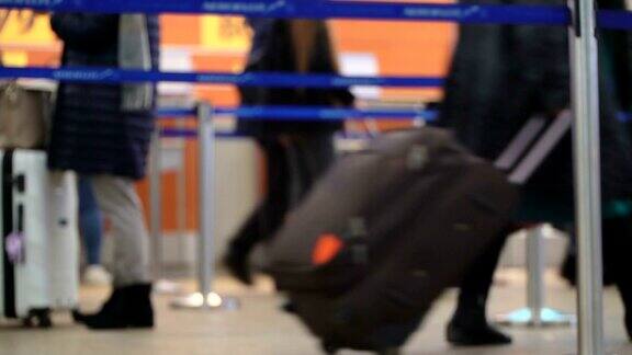 旅客在国际机场的离港候机楼排队办理检票手续机场乘客的行李和手推车实时