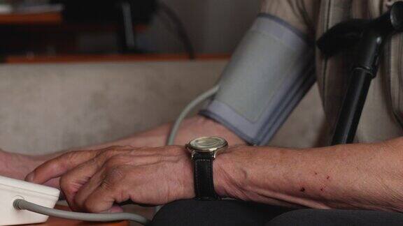 一位退休老人在家里用血压计测量自己的血压老年时注意心脏健康预防中风心脏病发作是健康的