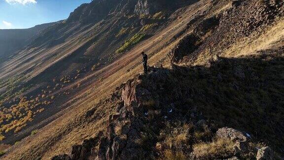日落时分商人在岩石山顶徒步旅行