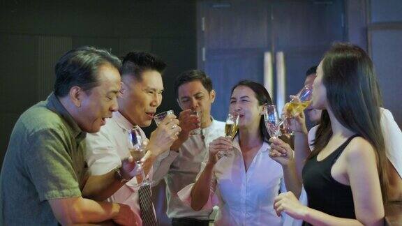 快乐的亚洲同事在酒吧庆祝工作派对