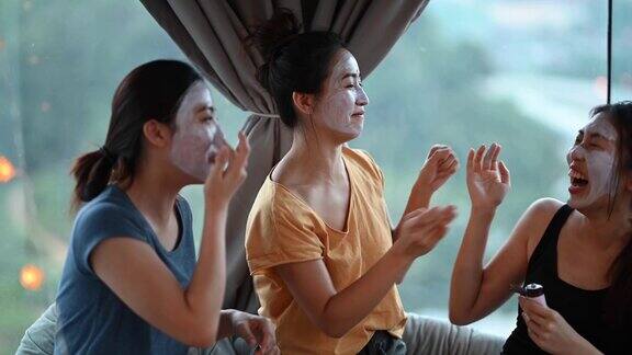 3个亚洲华人美女在卧室里敷面膜享受团聚的快乐时光