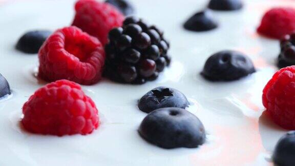 天然酸奶与野生浆果循环旋转健康食品成熟的蓝莓覆盆子黑莓在酸奶转弯