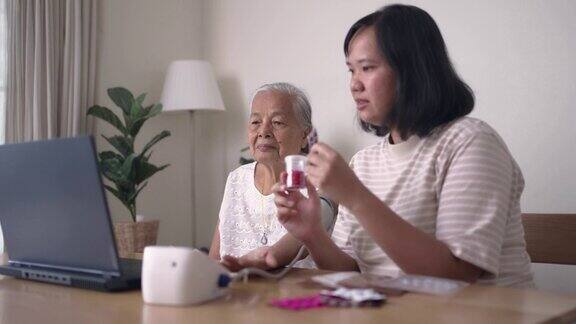 一名妇女正在帮助祖母与医生通过笔记本电脑进行远程医疗视频通话