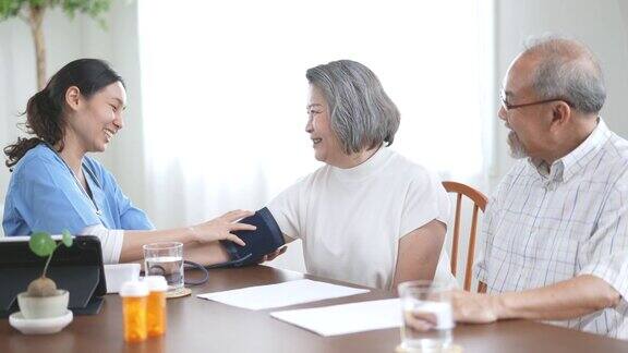护士在家为老年夫妇检查血压