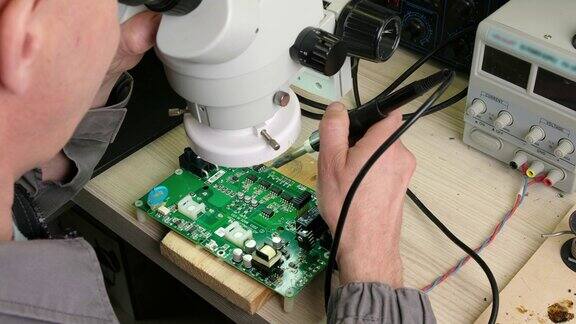工程技术员调整显微镜使之工作修理工焊接电子设备的电路板