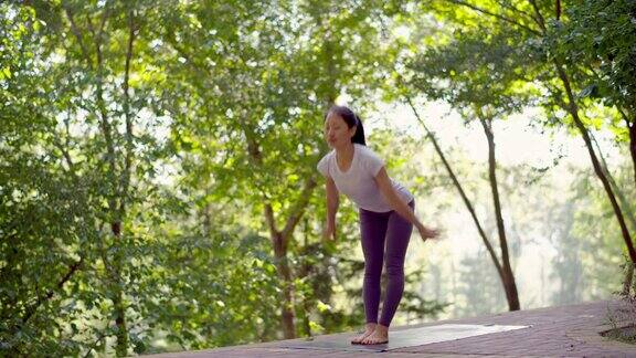 年轻的亚洲女性在城市公园练习瑜伽