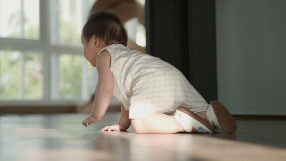 快乐的女婴在地板上爬享受着快乐的童年