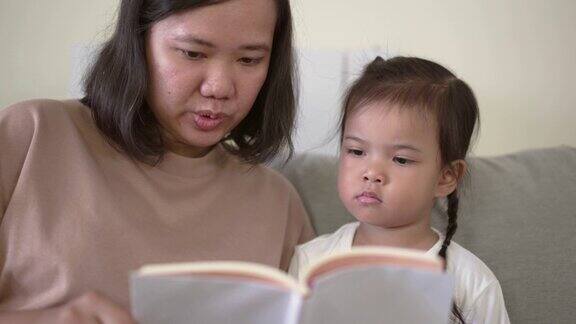 妈妈在教她的女儿一起读书
