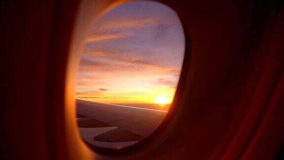 在早晨看着飞机的窗户和美丽多彩的天空
